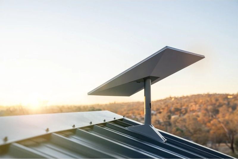 Antenne satellite installée sur un toit en bac acier au coucher du soleil